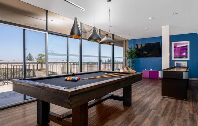 A pool table in a room with a view of the ocean.