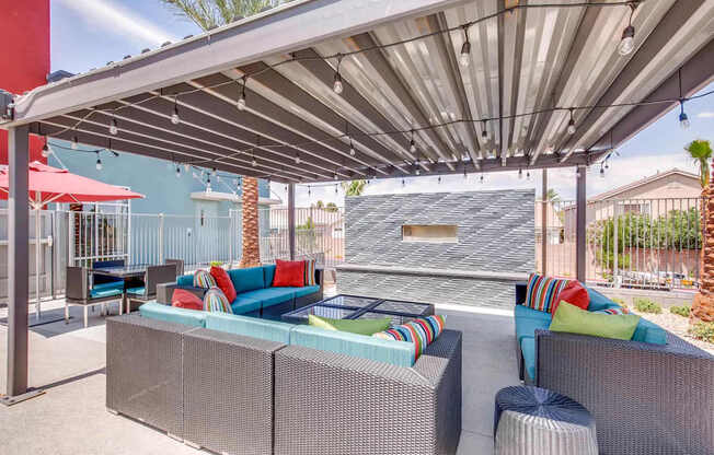 A patio with a grey canopy and a blue couch.