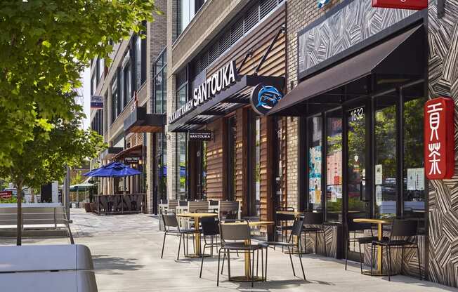 a sidewalk with tables and chairs in front of a restaurant at The Boro, Tysons, VA 22102