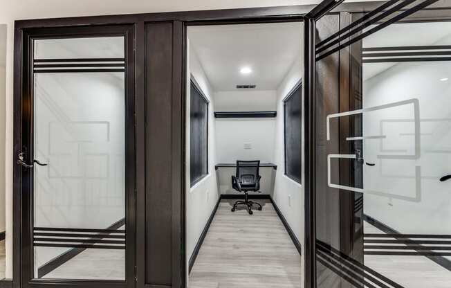 a corridor with a chair and a glass door