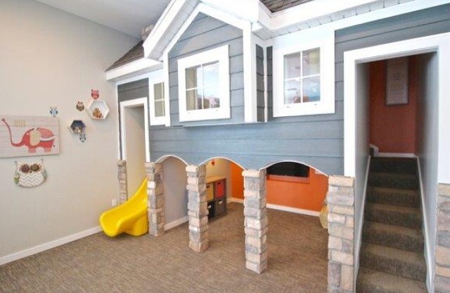Playroom showing 2-level playhouse with slide and flat screen T.V.