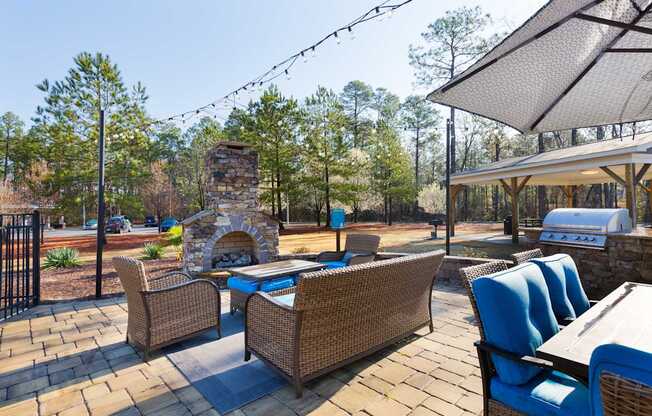 A patio with a table and chairs and a fireplace.
