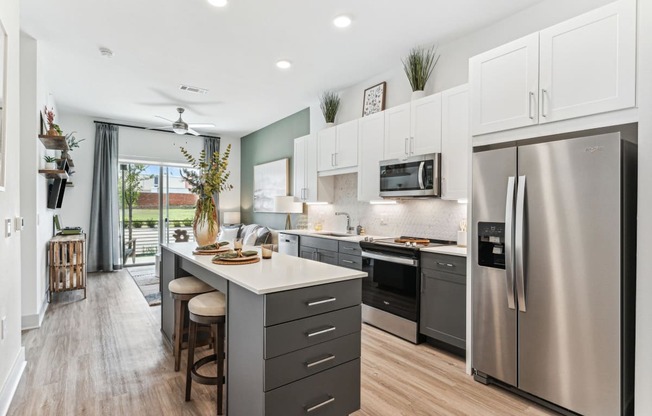 a kitchen with stainless steel appliances and a large island with stools