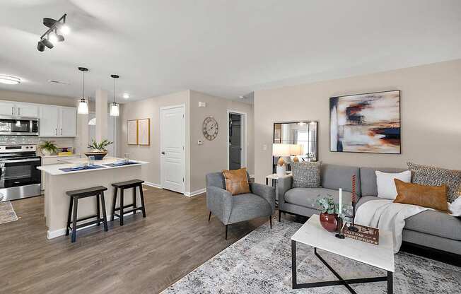 A modern living room with a kitchen area in the background.