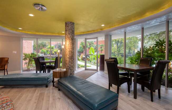 a living room with a large yellow ceiling and large windows