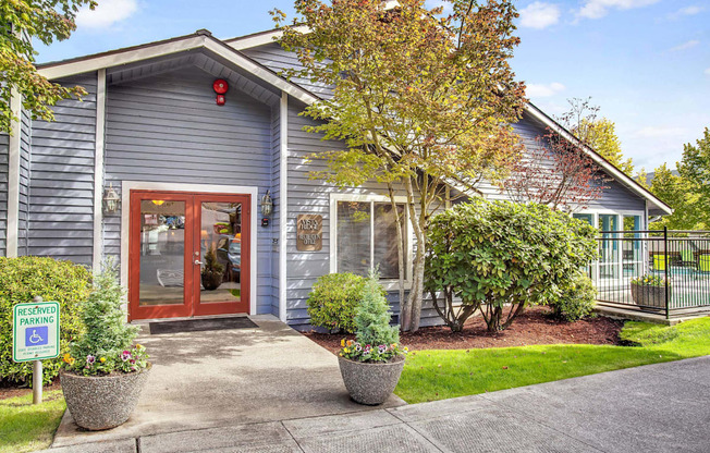 the front of a blue house with a red door