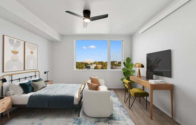 A bedroom with a bed, chair, and a television.