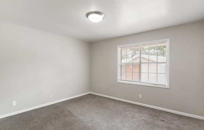 an empty room with carpet and a window