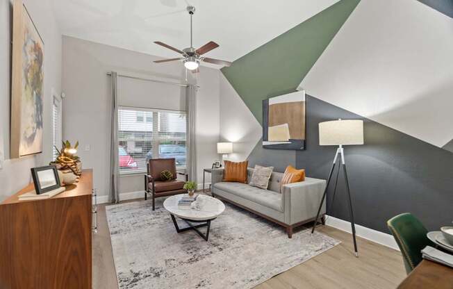 A living room with a white couch and a ceiling fan.