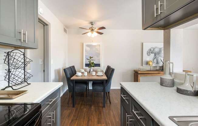an open kitchen with a dining table and a ceiling fan