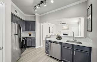 A modern kitchen with a refrigerator, sink, and cabinets.