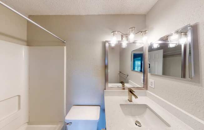a bathroom with a sink mirror and toilet