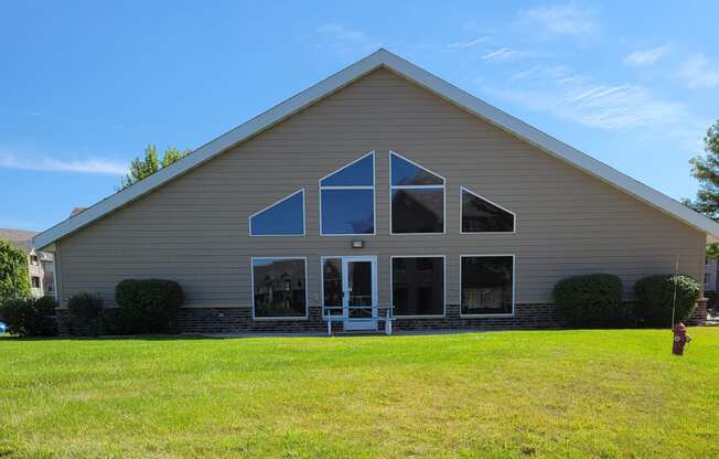 a view of the front of a church with a grass field in front