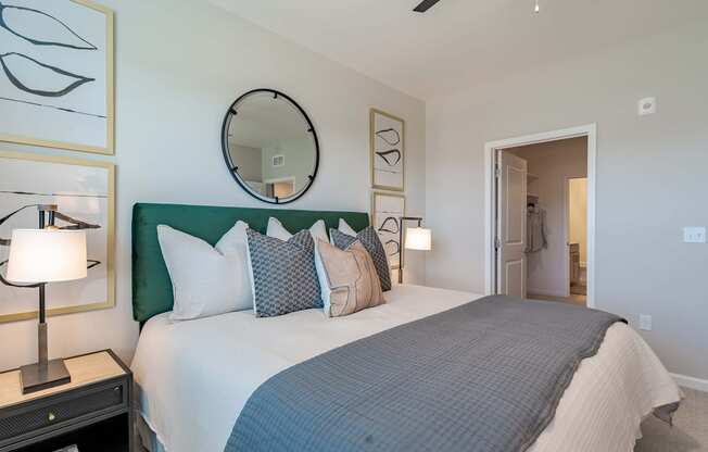1-Bedroom Apartments in Madison, AL - Paxton Place - Spacious Bedroom with Plush Carpet, Bed, Nightstands with Lamps, Mirror, and Spacious Closet.