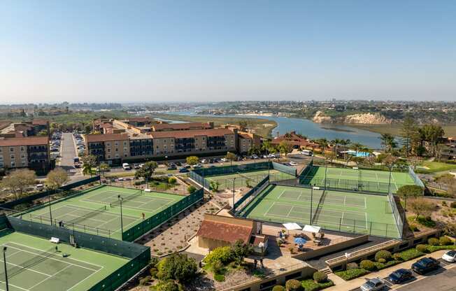 an aerial view of a tennis court with a city in the background