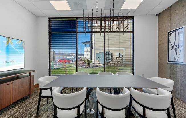 a room with a large window and a table with chairs