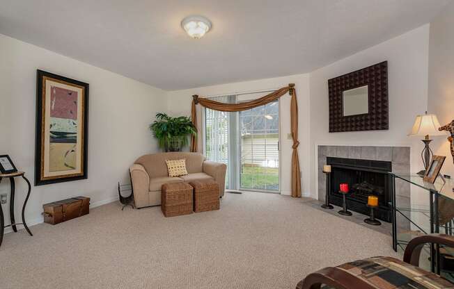 A living room with a fireplace and a couch.at Camden Place, Dublin Ohio