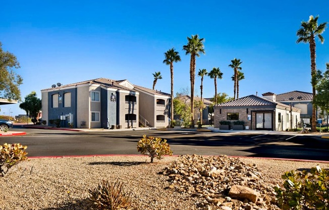 a house on a street with palm trees in the background