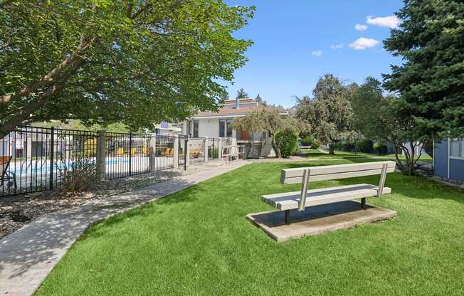 A bench sits in the middle of a grassy area.
