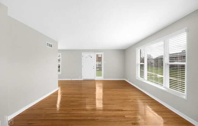 a bedroom with hardwood floors and grey walls