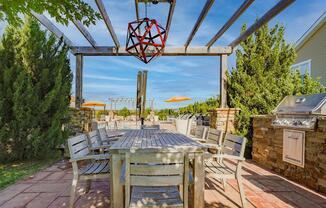 the patio has a dining table and chairs and a grill