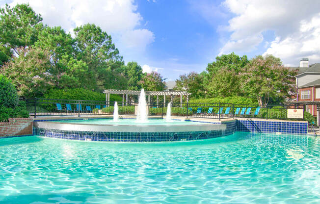 Enclave at Wolfchase Apartments in Cordova Tennessee photo of a fountain in the middle of a pool with a pergola in the background