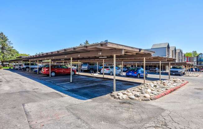 A parking lot with a building in the background and cars parked in the lot.