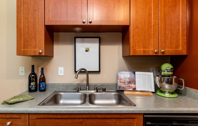 a kitchen with wood cabinets and a stainless steel sink