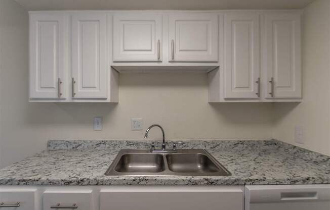 A kitchen with white cabinets at Princeton Court Apartments in the Vickery Midtown neighborhood of Dallas, TX.