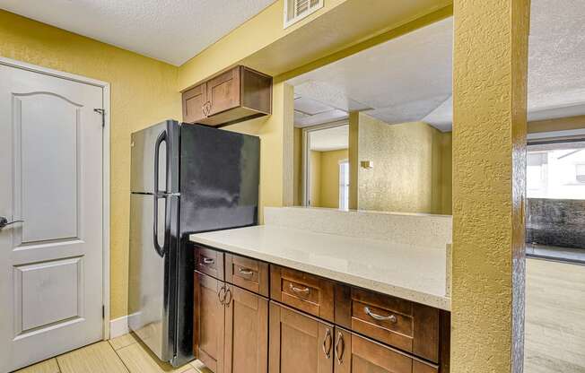 a kitchen with a refrigerator and wooden cabinets