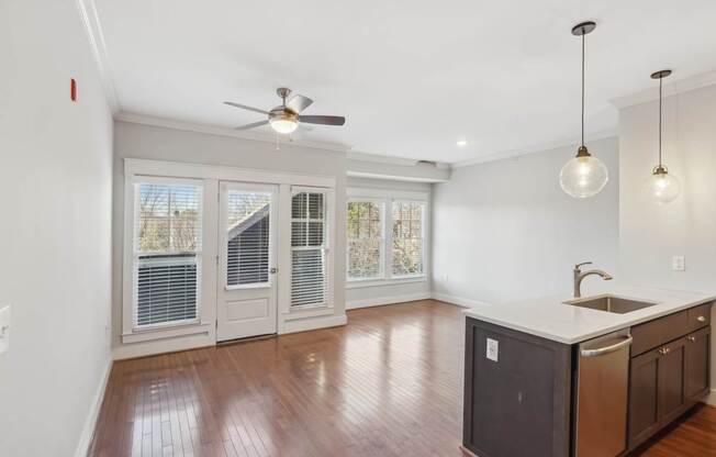 A kitchen with a fan on the ceiling and a sink in the middle.