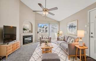 a living room with a ceiling fan and a tv