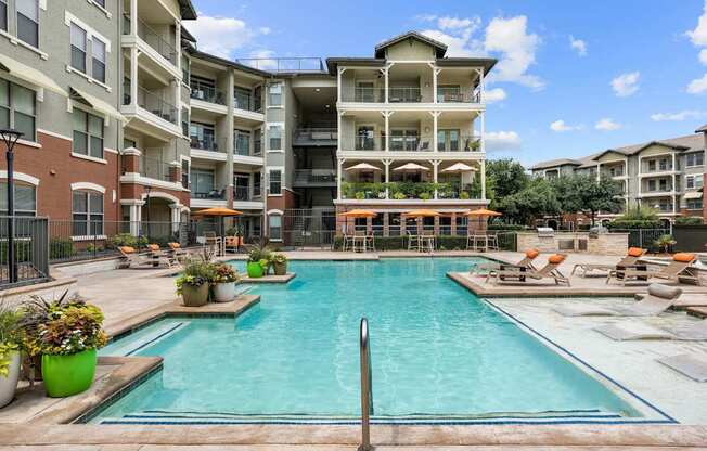 A large swimming pool in front of apartment buildings.
