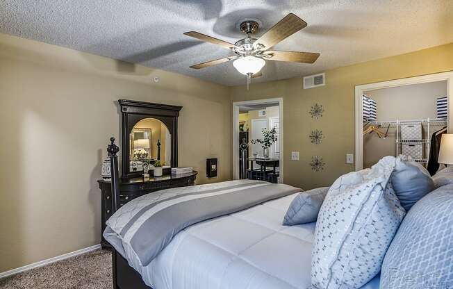 A bedroom with a large bed and a ceiling fan.