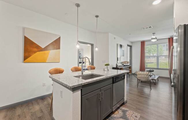 A modern kitchen with a large island and a painting on the wall.