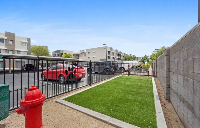 a fire hydrant sits on a small patch of grass in front of an apartment complex