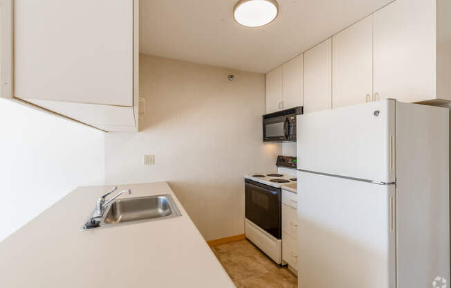 A kitchen with white appliances and a white counter.