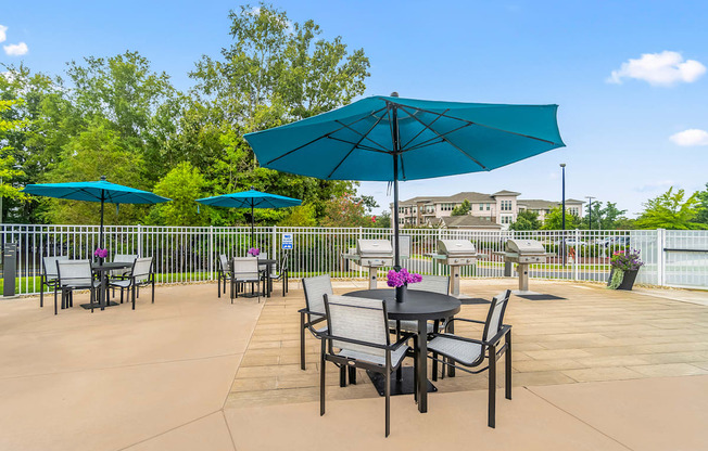 a patio with tables and chairs and umbrellas