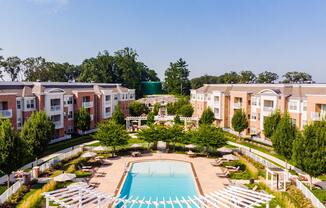 an aerial view of a pool with apartments in the background
