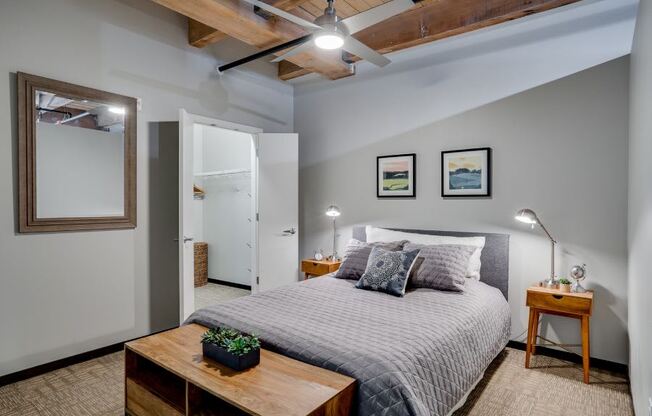 Loft style bedroom with exposed wood ceilings and walk-in closet