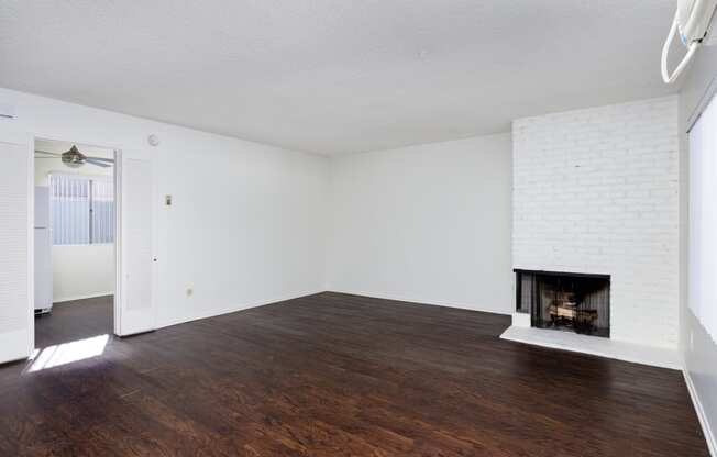 an empty living room with white walls and a fireplace