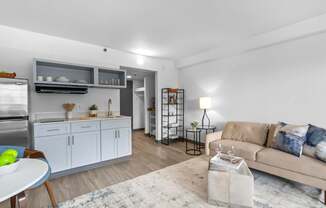A modern kitchen with a dining table and a couch in the living room.
