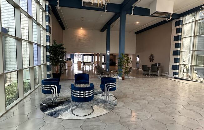 a large lobby with a chandelier and blue chairs