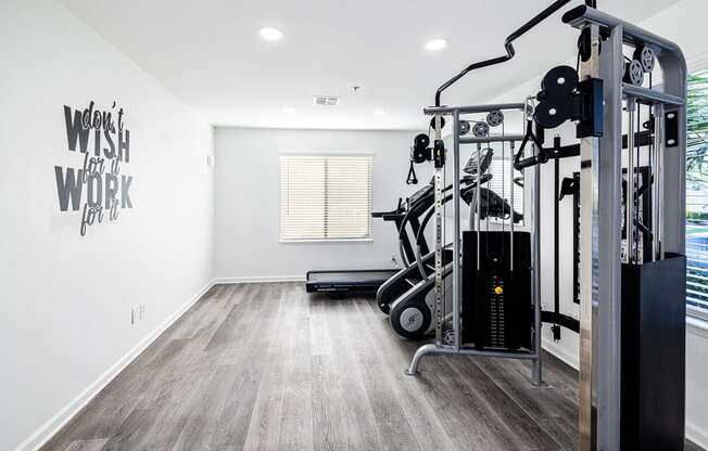 a home gym with exercise equipment and a window