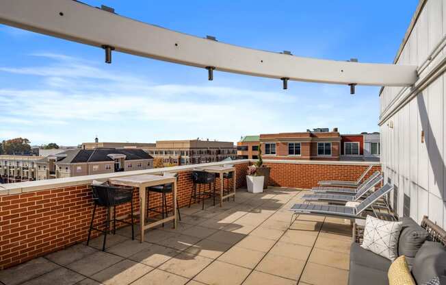 a patio with tables and chairs on a roof top