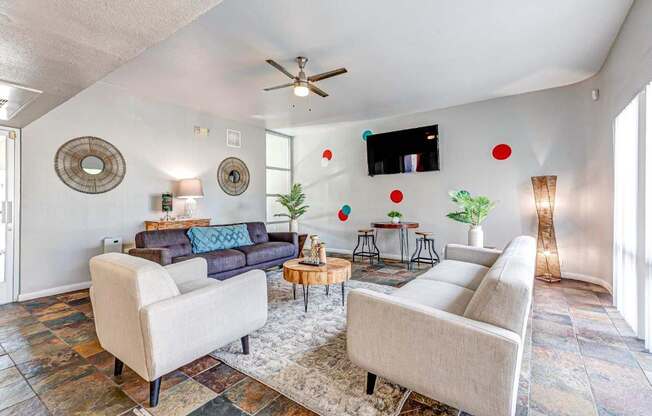 A living room with a blue couch and a white chair.