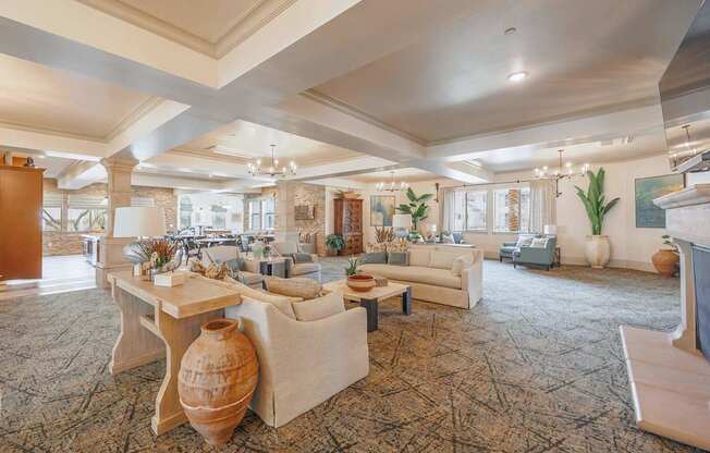 A large, well-lit living room with a carpeted floor and a variety of furniture.