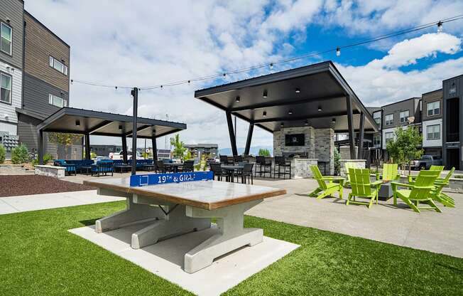 a picnic area with a table and chairs in front of a building