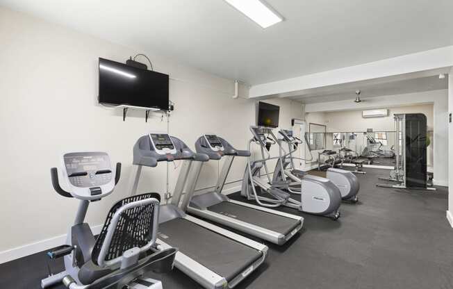 Resident Fitness Center with Cardio equipment and a flat screen tv at Malloy Apartment Homes in Seattle, WA, 98105