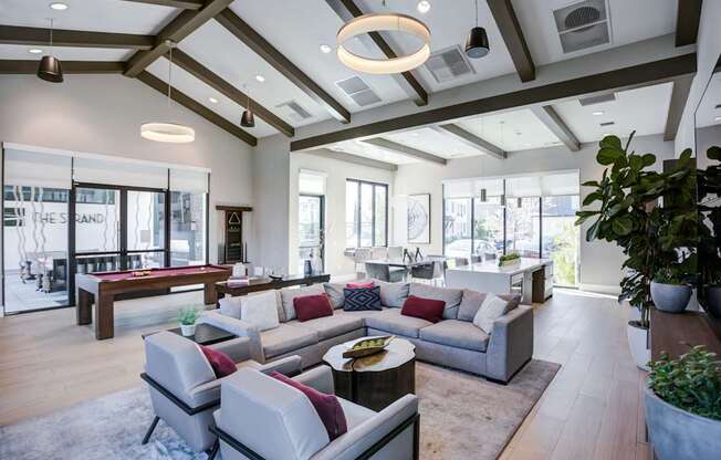 A modern living room with a large grey sofa and a wooden coffee table.